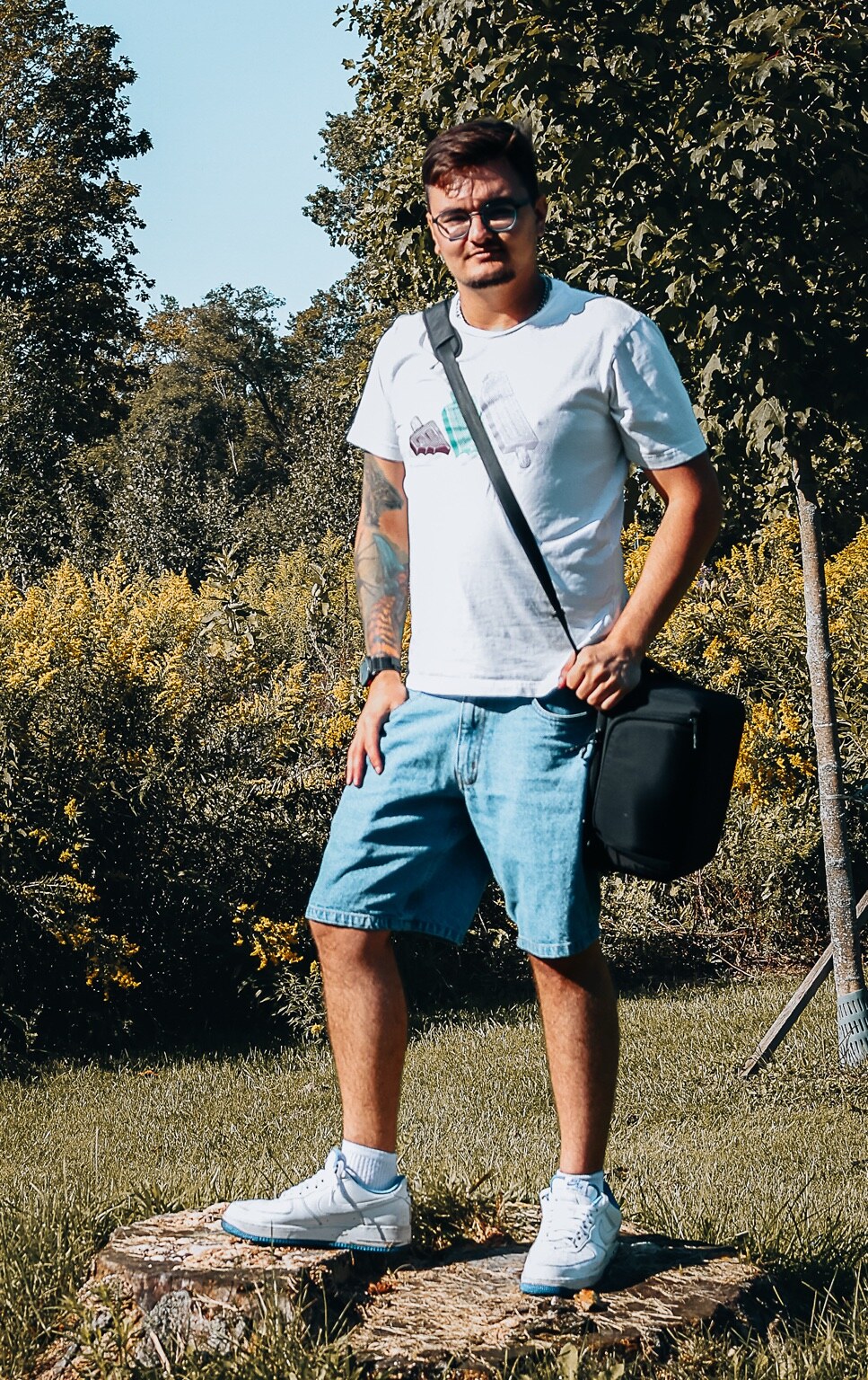 Zack Robert standing outdoors with his camera bag